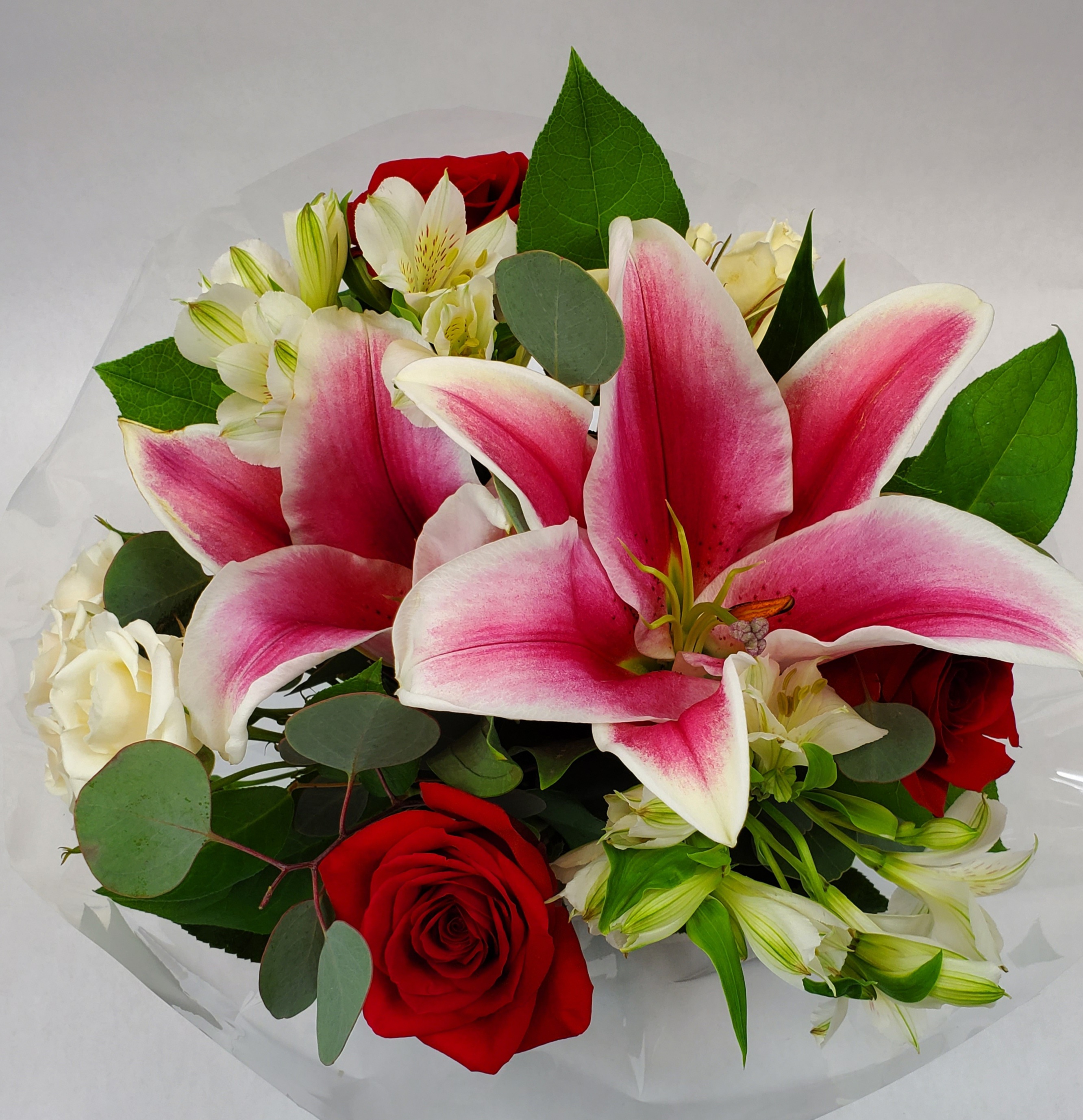 A photo of a bouquet with pink, red, and white flowers