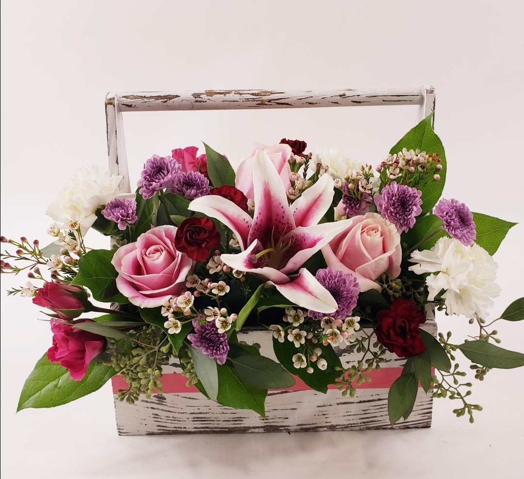 A photo of a bouquet with purple, pink, and maroon colored flowers