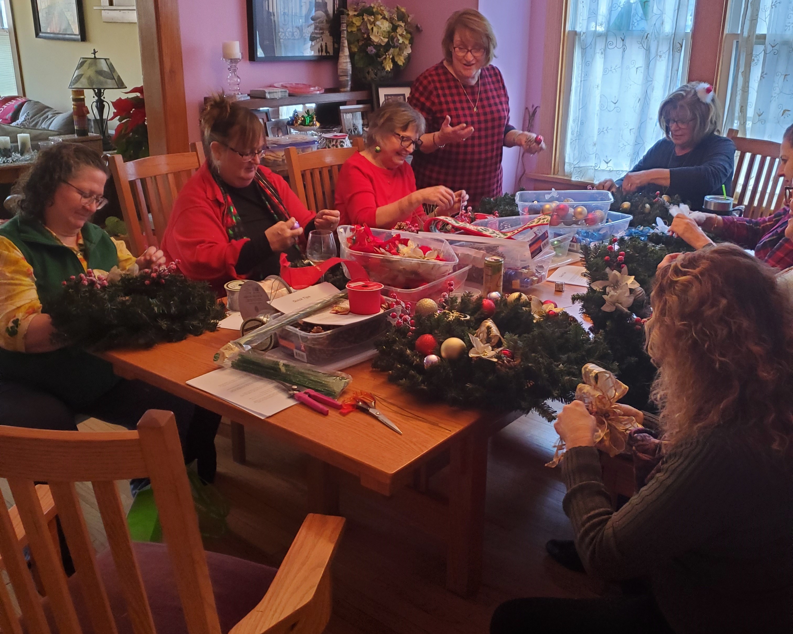 A picture of ladies around a table working on christmas wreaths