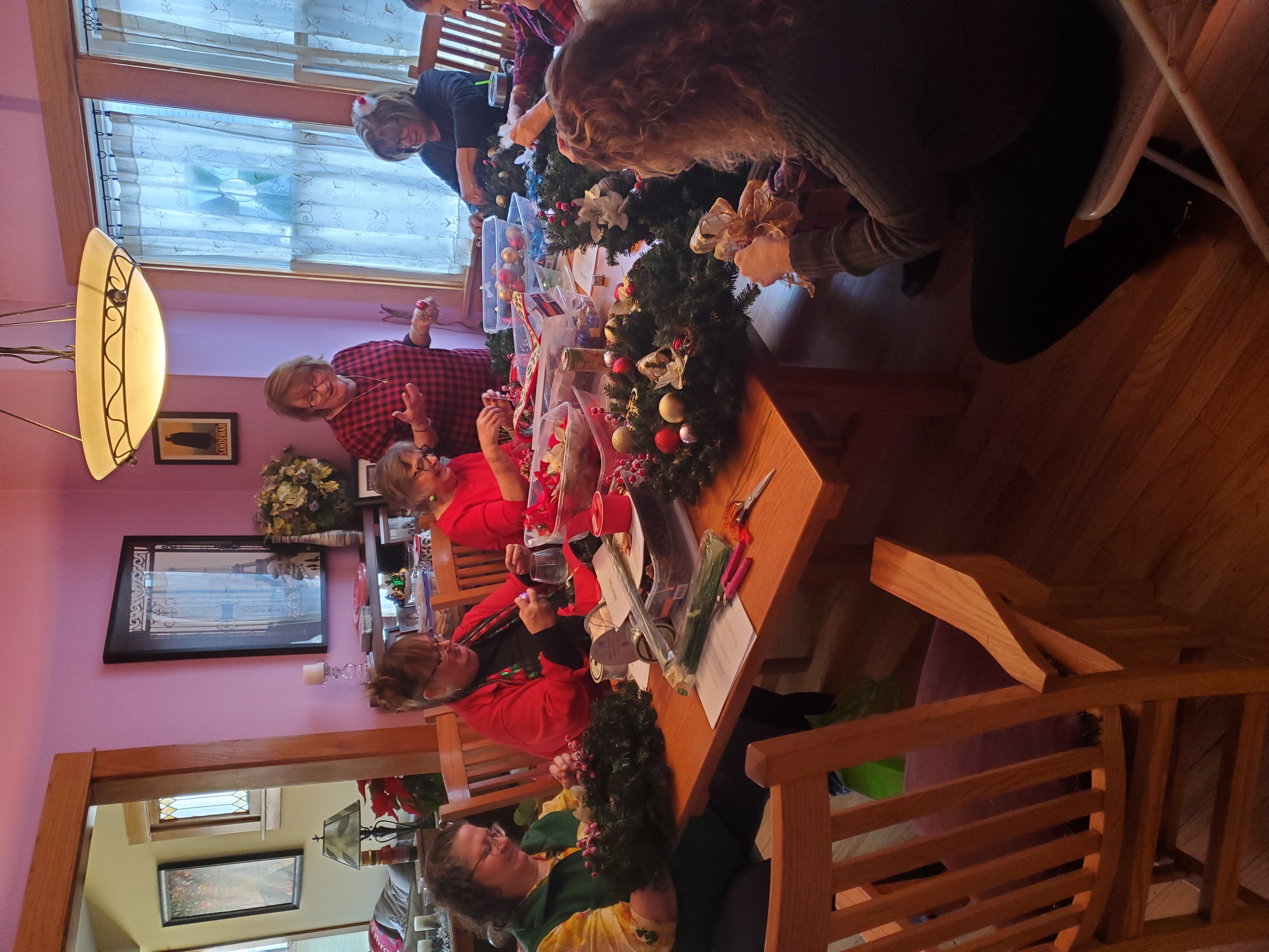 A picture of people around a table making flower arrangements